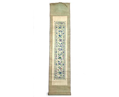 A late 19th century Chinese silk embroidered sleeve band panel mounted on a scroll, embroidered with birds amongst foliage in