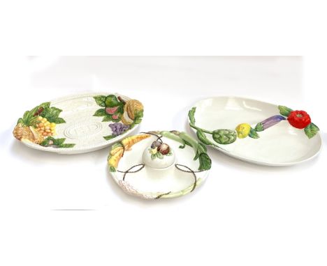 A large Italian Cre Art majolica serving dish painted with fruit and vegetables, 54cmW; together with two similar French cera