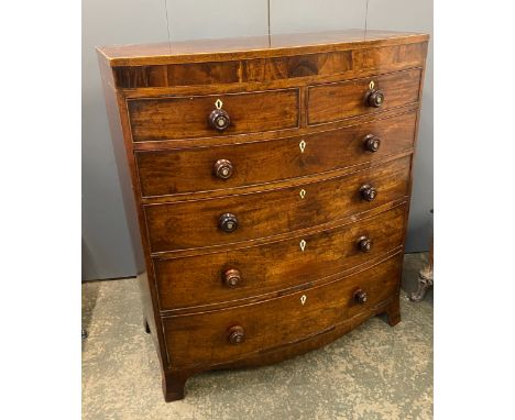 An early 19th century bow front mahogany chest of two short over four graduating doors on bracket feet, with later turned woo
