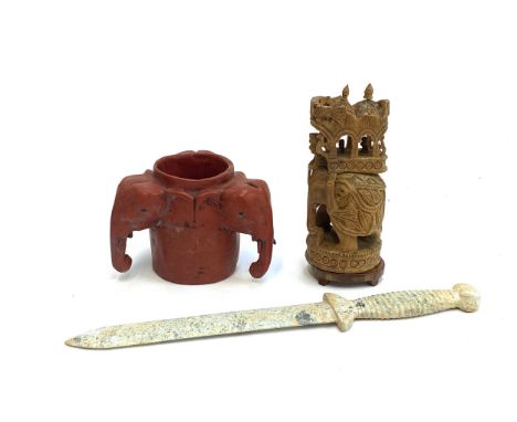 A red lacquered wooden tri handled elephant cup, 10.5cmH, together with a carved stone dagger, 35cmL, and a carved wooden ele