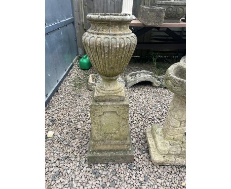 Stone urn shaped planter on plinth 