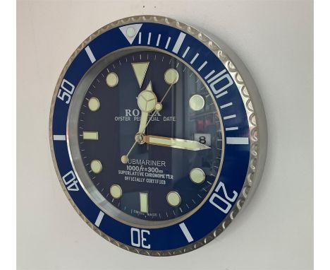 Modern wall clock designed to look like Rolex's legendary 'Submariner'.Stainless steel bezel with mineral glass front, silent