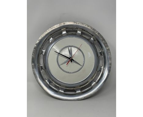 Innovative use of a characterful Mercedes-Benz wheeltrim.  White centre, working clock and roughly circular. Measuring 14" in