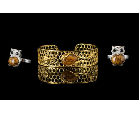 Two Natural Honey Jasper Set Items comprising a honeycomb and bee cuff bangle and an owl ring; the bangle of openwork honeyco