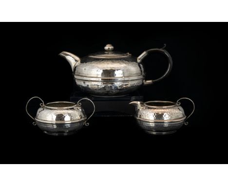 Arts And Crafts Three Piece Plated Planished Tea Set Of Squat form, comprising teapot, sugar bowl and milk jug. Each in good 