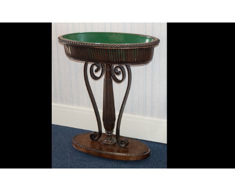 A Mahogany Plant Trough - raised on oval base with reeded, graduating support with further scroll support; oval bowl to top w