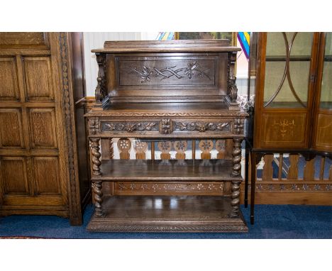 A Carved Oak Continental Buffet Of large proportion with barley twist supports, two shelves and two frieze drawers, carved th