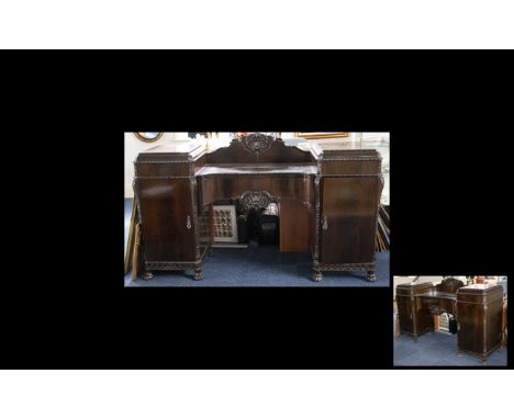 A 20th Century Regency Style Buffet Of very large proportion with central drawer between two cupboards with carved detail thr