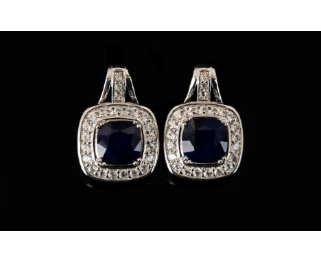 Sapphire and Natural White Zircon Drop Earrings, with ruby accents; each earring comprising a square cushion cut sapphire of 