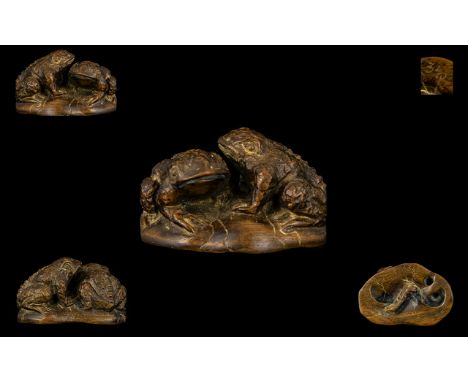 A Carved Fruitwood Netsuke In The Form Of A Pair Of Toads Finely carved with worm carved to base and etched mark, length 4 in