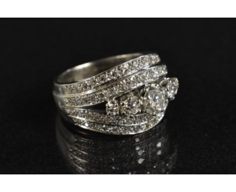 A diamond cluster ring, central quintet of graduated round brilliant cut diamonds, flanked by two stepped rows of conforming 