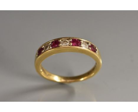 A ruby and diamond seven stone line ring. alternate set with four pinky red rubies and three diamonds, total estimated diamon