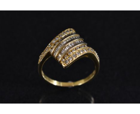 A diamond cluster ring, arching diamond shaped platform encrusted with twenty six trapezoid/baguette and thirty eight round c