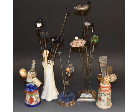 A silver hatpin stand; another plated; ceramic hat pin stand; a quantity of hatpins to include an enamelled silver butterfly 