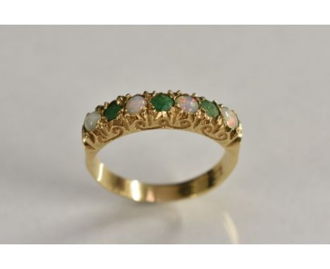 A Victorian seven stone emerald and opal ring, linear set with four opals and three emeralds, yellow gold shank, marks worn, 