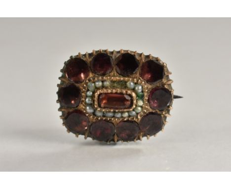 An early 19th century garnet and seed pearl cushion brooch, central pinky red baguette garnet, surrounded by a bands of seed 