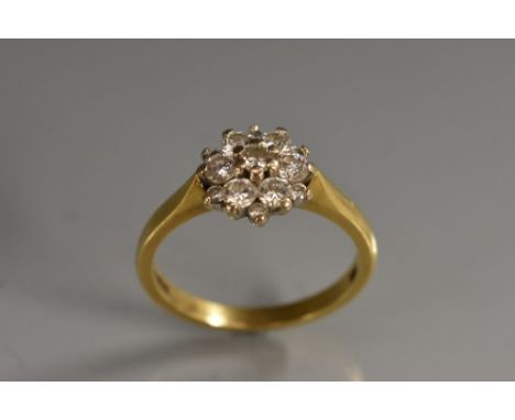 A diamond daisy head cluster ring, central round brillinat cut diamond surrounded by two stepped bands of six graduated confo
