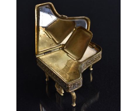 A gilt brass novelty musical powder compact, as a grand piano, The Pygmalion