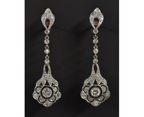 A pair of Art Deco diamond floral drop earrings, each encrusted with twenty three round and irregular cut diamonds, total est