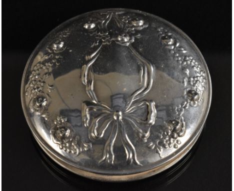 A silver compact, decorated in relief with ribbon and bow, kid leather case