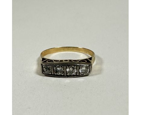 An Edwardian yellow and white metal ring set four graduated old cut Diamonds in millegrain setting, one with chip to table, N