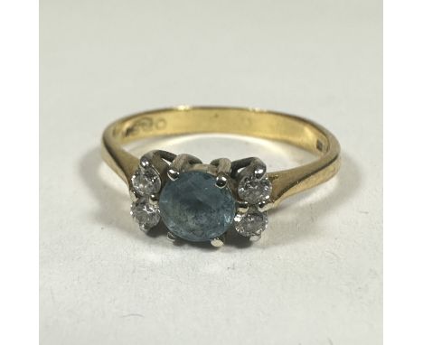 A 18ct gold Aquamarine ring, the circular stone approximately 0.33ct flanled by tow clear stones, K. 2.23g