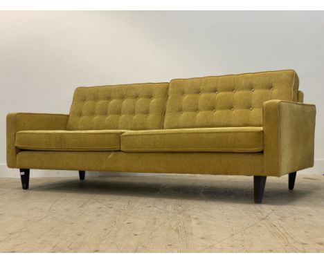 A large contemporary sofa, upholstered in yellow chenille type fabric, raised on ebonised square tapered supports (hole in th