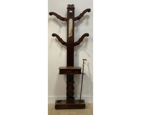 A Victorian walnut hall stand, the mirrored back with eight turned coat hooks above a glove box and an umbrella stand with dr