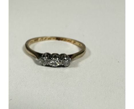 A 9ct gold three stone diamond ring set in platinum claw setting, K. 1.06g