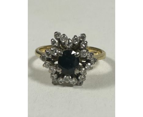 A 18ct gold Sapphire and Diamond cluster ring of star design, the oval Sapphire approximately 0.5ct enclosed within a radiati