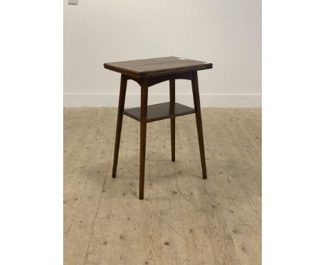 An Edwardian oak card table, the fold over revolving top opening to a baize lined playing surface, raised on square tapered s