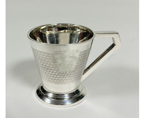 A Birmingham silver Art Deco christening cup of tapered cylindrical form with squared handle to side and all over engine turn