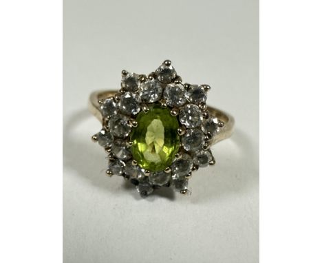 A 9ct gold oval Peridot and CZ set cluster ring, the Peridot approximately 0.75ct, P. 3.68g