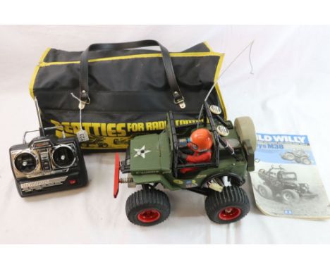 A Tamiya 1/10th scale Wild Willy Willys M38 radio control stunt vehicle complete with remote control and assembly manual stor