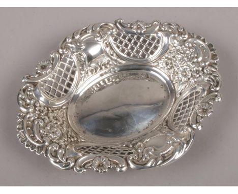 A silver oval dish with lattice pierced sides and repousse decoration, assayed Sheffield 1914. (61g).  