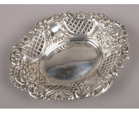 A silver oval dish with lattice pierced sides and repousse decoration, assayed Sheffield 1914. (61g).  