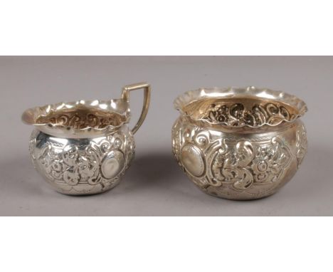 A Victorian silver cream jug and matching sugar bowl with repousse decoration, assayed London 1896 Josiah Williams &amp; Co. 