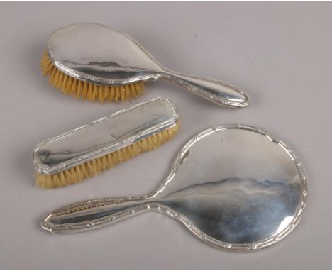 A George V silver three part dressing table set assayed Birmingham 1911 by William Neale &amp; Son Ltd.  Dents and scratches 