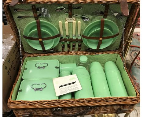A vintage cane coracle picnic basket with Bandalasta and Thermos green plastic fittings