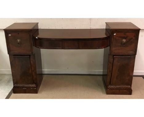 A Regency mahogany pedestal sideboard with central bow fronted three drawer section flanked by slightly tapered pedestals wit