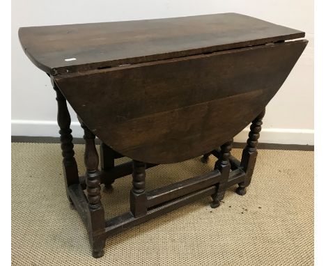 An 18th Century and later oak oval gate-leg drop-leaf dining table on turned supports to block feet united by stretchers, 109