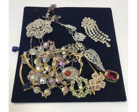 A collection of vintage paste necklaces and brooches, together with a box of vintage bracelets, a vintage metal and red and b