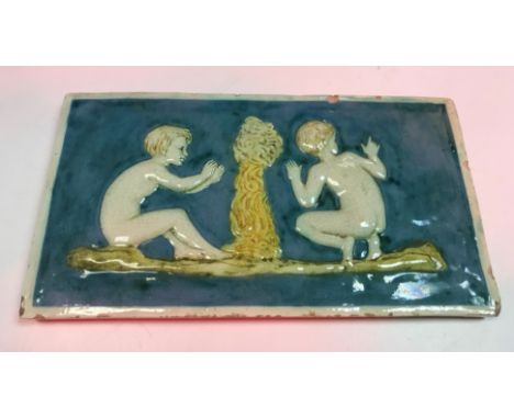 A Della Robbia rectangular tile depicting two children either side of a smoking fire 13 cm x 24 cm bears "Della Robbia" mark 