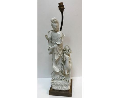 A 18th Century Chinese blanc de chine figure of Guan Yin, a young deer at her side with basket of flowers upon its back, 43 c