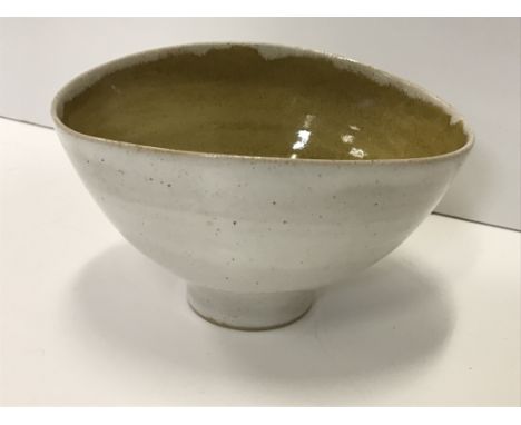 A Lucie Rie and Hans Coper white speckled glazed elliptical bowl with ochre interior, bearing both maker's marks to base, 11.