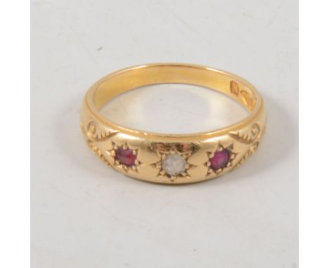 A ruby and diamond three stone ring, the stones star gypsy set in an 18 carat yellow gold polished tapered band, hallmarked C