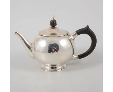 A small modern beaten silver bullet shape teapot, ebony handle and finial, 14cm high, hallmarked Birmingham 1977 with Jubilee