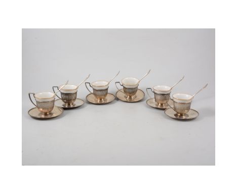 Set of six J S silver saucers, with silver tea cup holders and six ceramic insert cups and six silver tea spoons.