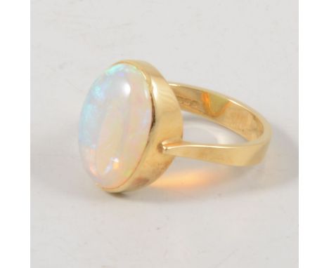 An opal dress ring, the oval cabochon cut stone, 13mm x 10mm collet set in an 18 carat yellow gold mount, hallmarked Birmingh