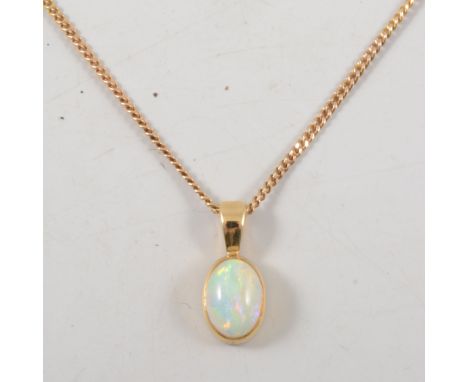 An opal pendant, the oval cabochon cut stone, 9mm x 6mm collet set in a yellow metal mount on a 9 carat yellow gold flat curb